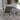 Modern outdoor chair with a small table on a patterned rug, with decorative elements in the background.