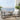 Outdoor patio set with two rocking chairs, a small table, and plants on a balcony with ocean view.