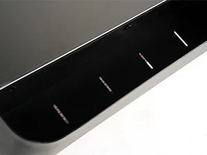 Close-up of a car's black rear bumper with visible scratches on a white background