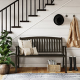 Grand Patio outdoor bench with faux wood finish, placed against a white wall, featuring decorative pillows and plants.