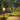 Outdoor garden lights illuminating a pathway next to a pool at night.