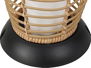 Wicker basket on a black base with a white candle inside