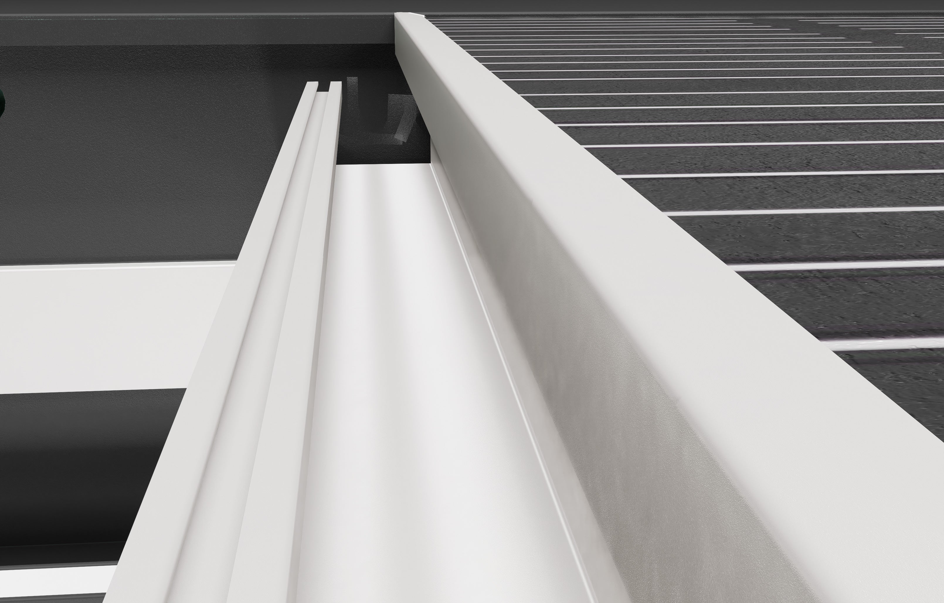Close-up of a white metal gutter system with black background