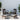 Outdoor patio set with chairs, table, and ottoman on a light blue background