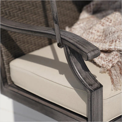 Close-up of a wicker chair with a cushion and textured surface in the background