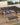 Outdoor patio set with sectional sofa, coffee table, and bench on a wooden deck.
