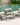 Outdoor patio set with chairs and a table by a pool