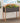 Gray planter box with wooden frame filled with flowers on a wooden deck.