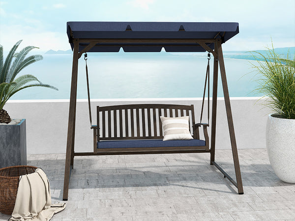 Outdoor swing bench with canopy on a patio with plants and ocean view