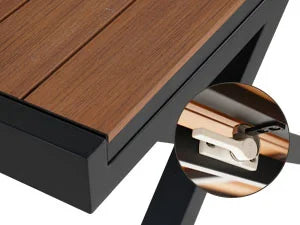 Close-up of a wooden table with metal legs, focusing on the connection point.
