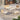 Grand Patio spring wicker patio furniture set with two chairs, a bench, and a coffee table on a stone patio.