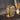 Decorative lantern with plants on a table next to a vase with dried plants.