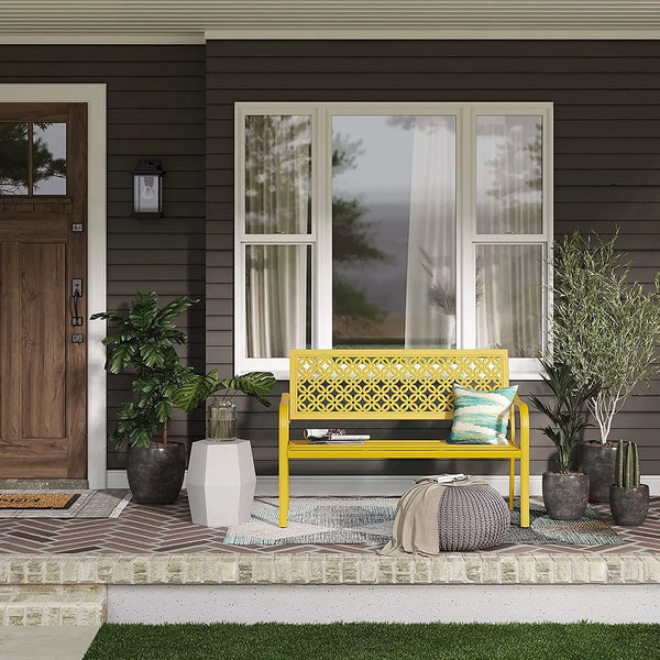 Yellow bench on a front porch with decorative items and plants.