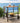 Outdoor bar cart with drinks and fruit on a wooden deck with ocean view