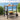 Outdoor bar cart with drinks and fruit on a wooden deck with ocean view