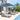 Outdoor patio furniture set with lounge chairs and umbrellas by a poolside.
