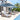 Outdoor patio furniture set with lounge chairs and umbrellas by a poolside.
