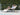 Woman relaxing on a lounge chair by a pool with a scenic background