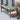 Wicker bench with sunglasses and a cushion on a patio