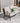 Outdoor sofa with light gray cushions and a green pillow on a patio.