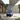 Grand Patio outdoor wicker sectional sofa with thick blue cushions and a steel frame, set on a patio with stone walls.