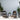 Outdoor patio furniture set with chairs, ottoman, and table on a patio with plants and a heater.