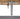 Tapered metal leg of a patio chair with rattan seat on a white background