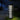 Decorative outdoor lamp with geometric pattern on a grassy area at night.