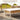 Grand Patio wicker patio furniture set featuring a coffee table and cushioned seating in a sunny outdoor setting.