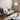Modern living room with a gray sofa, round white coffee table, and decorative elements.