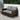 Grand Patio outdoor wicker sectional sofa with thick gray cushions and a steel frame, set on a patio with greenery.