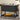 Wicker bar cart with a plate of oranges on a wooden floor.