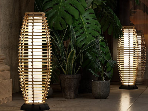 Decorative outdoor lamps with a warm glow in front of potted plants.