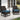 Two wicker chairs with blue cushions on a patio.