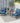 Outdoor patio set with two blue cushioned chairs and a small table on a patio.