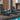 Outdoor furniture set with wicker chairs and ottomans on a wooden deck by a pool.