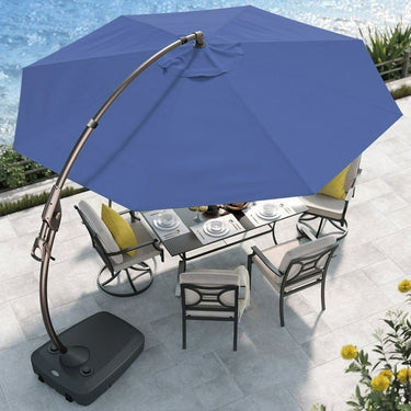 Large blue cantilever patio umbrella with a bronze frame, positioned over a dining table and chairs on a stone patio.