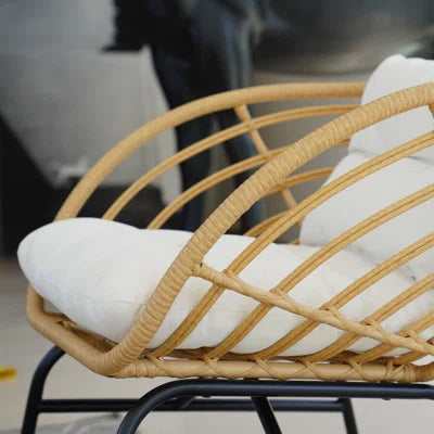 Wicker chair with white cushion in a blurred indoor setting