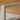 Close-up of a chair with woven backrest and beige cushion.