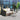 Grand Patio outdoor wicker sectional sofa with thick gray cushions and a small round table on a patio.