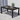 Black outdoor dining table with a plant, cups, and a magazine on a patio.
