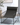 Black lounge chair in a room with a plant and rug